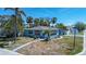 Charming corner lot home featuring lush landscaping, mature palms, and a beautiful turquoise exterior at 512 79Th Ave, St Pete Beach, FL 33706
