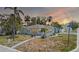 Charming light blue home featuring tropical landscaping and a welcoming pathway under a stunning colorful sunset sky at 512 79Th Ave, St Pete Beach, FL 33706
