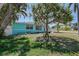 Front exterior view of a light blue home with lush landscaping and tropical plants under a clear blue sky at 512 79Th Ave, St Pete Beach, FL 33706