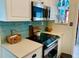 Bright kitchen with modern appliances, white cabinetry, and a black electric stovetop at 512 79Th Ave, St Pete Beach, FL 33706