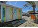 Fun backyard shed with colorful painted doors and string lights, perfect for outdoor entertaining at 512 79Th Ave, St Pete Beach, FL 33706