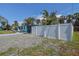 Yard surrounded by gravel and a white fence has palm trees and lush vegetation at 512 79Th Ave, St Pete Beach, FL 33706