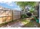 Backyard featuring a wood fence, grass, and mature landscaping at 5814 Silver Moon Ave, Tampa, FL 33625