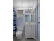 Cozy bathroom with a single sink vanity, toilet and blue and white shower curtain at 5814 Silver Moon Ave, Tampa, FL 33625