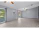 Spacious living room with neutral tile, ceiling fans, and sliding glass doors to the outside at 5814 Silver Moon Ave, Tampa, FL 33625