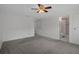 A carpeted main bedroom with a ceiling fan and a bathroom entrance at 5814 Silver Moon Ave, Tampa, FL 33625