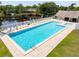 An aerial view of a large community pool with lounge chairs, next to a pond and gazebo at 6462 92Nd N Pl # 804, Pinellas Park, FL 33782