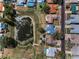 This aerial view shows neighboring homes with swimming pools near a pond filled with green algae at 8742 Bermuda Ln, Port Richey, FL 34668