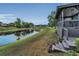Lake view from covered deck with railing and steps down to grass at 8742 Bermuda Ln, Port Richey, FL 34668