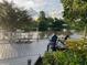 Backyard view from the deck with lake view and seating at 8742 Bermuda Ln, Port Richey, FL 34668