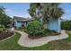 Exterior view with landscaped walkway, mature trees, and well-maintained garden beds at 8742 Bermuda Ln, Port Richey, FL 34668