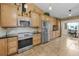 A bright kitchen is equipped with stainless steel appliances, and light wood cabinets at 8742 Bermuda Ln, Port Richey, FL 34668