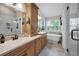 Bright bathroom featuring double sinks, modern fixtures, standalone tub, and a separate glass enclosed shower at 8742 Bermuda Ln, Port Richey, FL 34668