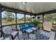 Inviting porch with comfortable seating, decorative rug, and scenic pond views at 8742 Bermuda Ln, Port Richey, FL 34668