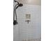 Modern glass enclosed shower with a built in soap niche, white subway tiles and pebble tile flooring at 8742 Bermuda Ln, Port Richey, FL 34668