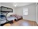 Bedroom with a bunk bed, wood-look flooring, a ceiling fan, and bright window at 9001 Tudor Dr # H210, Tampa, FL 33615