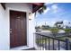 Exterior shot of a brown front door with unit number, framed by a palm tree and blue skies at 9001 Tudor Dr # H210, Tampa, FL 33615