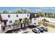 White two-story building with brown accents, surrounded by lush palm trees and well-maintained parking at 9001 Tudor Dr # H210, Tampa, FL 33615