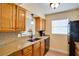 Kitchen featuring wood cabinets, granite counters, and black appliances at 9001 Tudor Dr # H210, Tampa, FL 33615