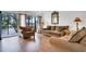 Sun-filled living room boasts hardwood floors, neutral furniture, and a sliding glass door at 9001 Tudor Dr # H210, Tampa, FL 33615