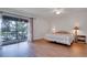 The main bedroom features an outside balcony entrance, ceiling fan, and laminate flooring at 9001 Tudor Dr # H210, Tampa, FL 33615