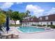 Community pool with lounge chairs surrounded by lush landscaping and multi-story buildings at 9001 Tudor Dr # H210, Tampa, FL 33615