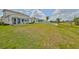 Wide view of backyard featuring patio and green lawn area extending to trees at 933 Signet Dr, Apollo Beach, FL 33572