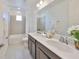 Bright bathroom with double vanity, quartz countertop, and tiled shower-tub combo at 933 Signet Dr, Apollo Beach, FL 33572