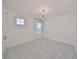 Bright bedroom with neutral carpet, modern light fixture, and sheer window curtains at 933 Signet Dr, Apollo Beach, FL 33572