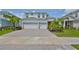 Beautiful two-story home with a brick driveway, three-car garage, and lush landscaping at 933 Signet Dr, Apollo Beach, FL 33572