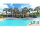 Beautiful community pool with palm trees and outdoor seating near the clubhouse at 933 Signet Dr, Apollo Beach, FL 33572