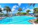Sparkling community pool with lap lanes, lounge chairs, and palm trees by the water at 933 Signet Dr, Apollo Beach, FL 33572