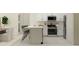 Well-equipped kitchen featuring stainless steel appliances, white cabinetry, and a breakfast bar at 9344 Cannon Beach Dr, Parrish, FL 34219
