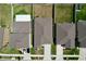 Overhead view of home roofs with neutral landscaping and white fences defining backyard spaces in a modern community at 9433 Channing Hill Dr, Sun City Center, FL 33573