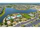 Aerial view of a community including a lake, pools, clubhouse, tennis courts, playground and parking at 9433 Channing Hill Dr, Sun City Center, FL 33573