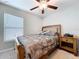 Cozy bedroom featuring a ceiling fan, bed with floral bedding, and a nightstand at 9433 Channing Hill Dr, Sun City Center, FL 33573