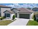 An elevated view of a single-story home with a manicured lawn and neutral color palette at 9433 Channing Hill Dr, Sun City Center, FL 33573