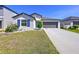 Charming single-story home with a well-manicured lawn, colorful flowerbed, and a two-car garage at 9433 Channing Hill Dr, Sun City Center, FL 33573