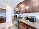 Gourmet kitchen featuring stainless steel appliances, granite countertops, and dark wood cabinetry at 9433 Channing Hill Dr, Sun City Center, FL 33573