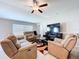 Inviting living room with plush reclining sofas, a ceiling fan, and a cozy atmosphere at 9433 Channing Hill Dr, Sun City Center, FL 33573