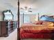 Spacious main bedroom with a four-poster bed and decorative wall mirror at 9433 Channing Hill Dr, Sun City Center, FL 33573
