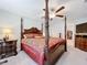 Bedroom with a four-poster bed, ceiling fan and view into the walk-in closet at 9433 Channing Hill Dr, Sun City Center, FL 33573
