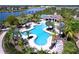 Community pool with tropical landscaping, luxurious seating, and plenty of space for relaxation at 9433 Channing Hill Dr, Sun City Center, FL 33573