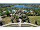Aerial shot of a luxurious community pool, clubhouse, and lush tropical landscaping at 9433 Channing Hill Dr, Sun City Center, FL 33573