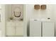 Bright laundry room features a modern washer, dryer, white cabinets, and stylish decor at 9816 Minnow Ray Dr, Land O Lakes, FL 34638