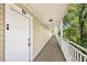 Condo hallway with door number 207 and railing with view of trees at 1000 W Horatio St # 207, Tampa, FL 33606