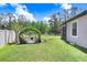Spacious backyard featuring a charming fire pit area with stone accents, perfect for outdoor gatherings and enjoying the lush greenery at 10703 Morning Dew Way, Tampa, FL 33647