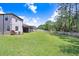 Lush backyard featuring a large manicured lawn, a covered patio, and well-maintained landscaping at 10703 Morning Dew Way, Tampa, FL 33647