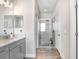 Bright bathroom features a glass-enclosed shower, wood-look tile flooring, and a gray vanity with a light countertop at 10703 Morning Dew Way, Tampa, FL 33647