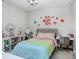 Charming bedroom features colorful decorations, a rainbow-themed bedspread, and a chandelier for a whimsical touch at 10703 Morning Dew Way, Tampa, FL 33647